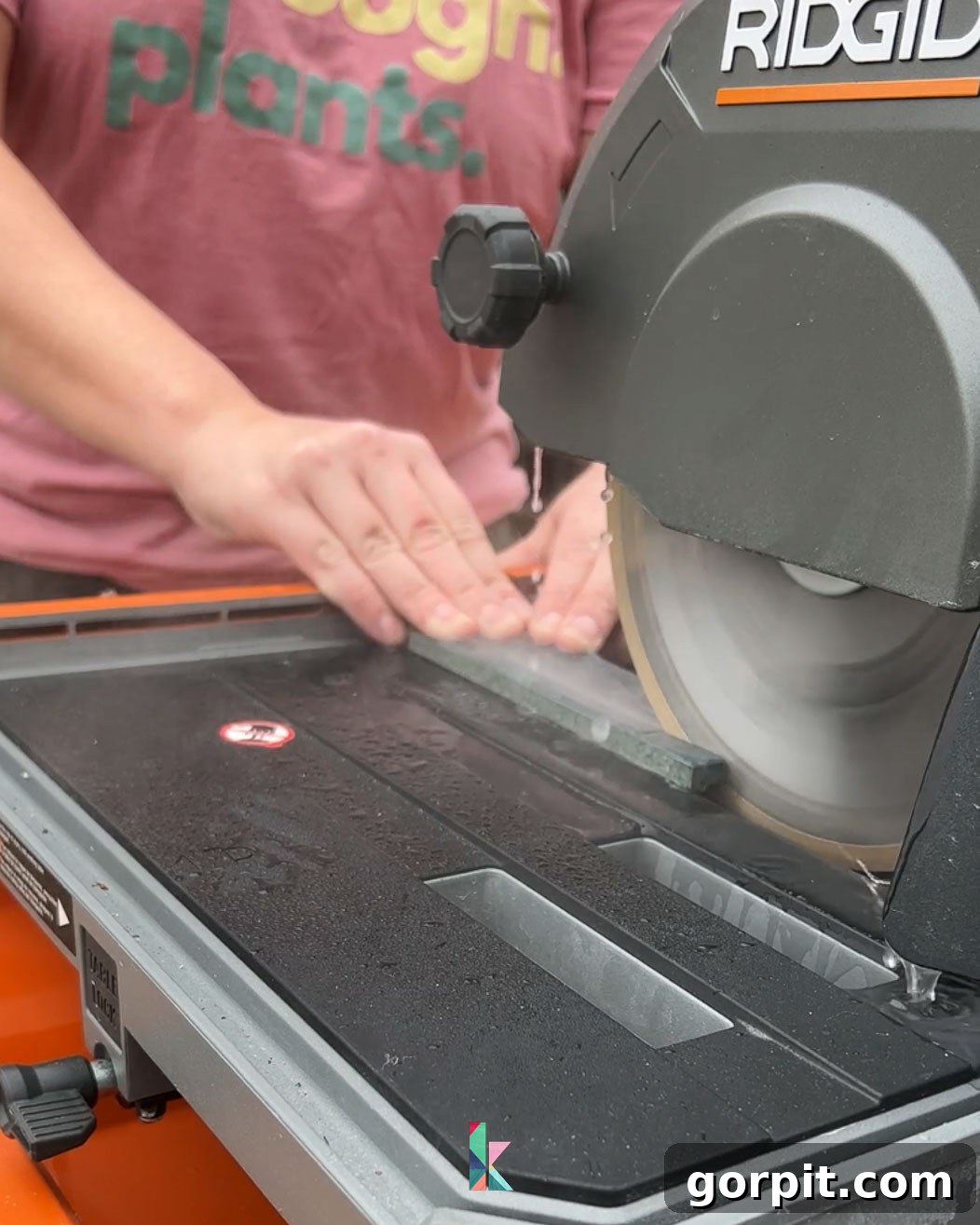 Cutting backsplash tile with a tile saw, demonstrating the precision required for fitting tiles around corners and obstacles during installation.