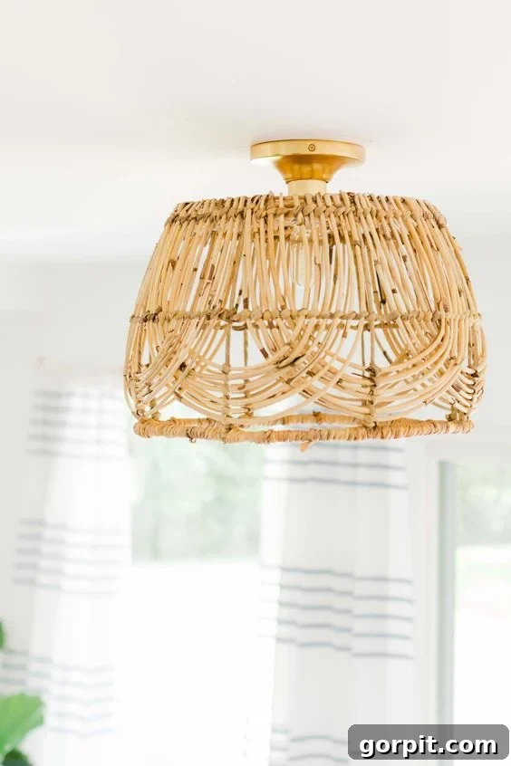 A beautifully crafted DIY basket-style pendant light, made from a woven basket, hangs gracefully from a white ceiling, casting a warm glow.