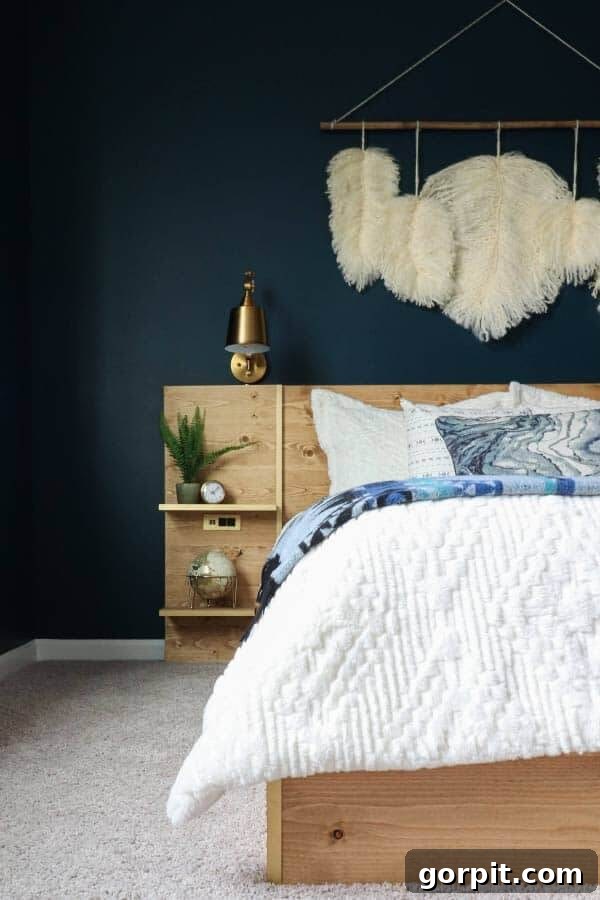 A moody navy wall painted with Moscow Midnight, featuring a platform bed, a white duvet, a light neutral carpet, and a light wood headboard, creating a cozy yet luxurious bedroom.