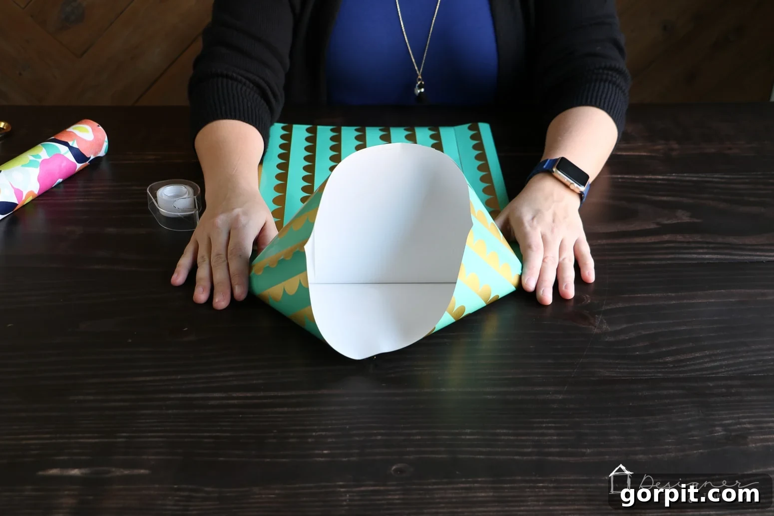Flattening the corners of the folded bottom to create a diamond shape, a crucial step in making a DIY gift bag base.