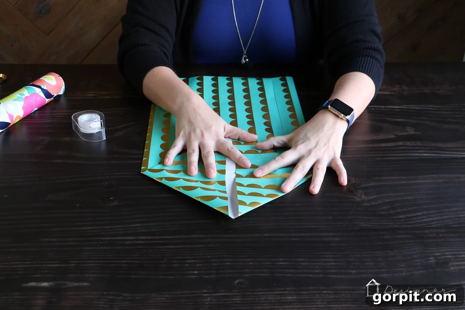 Close-up of the diamond-shaped base being formed on the wrapping paper, showing the precision required for a sturdy DIY gift bag.