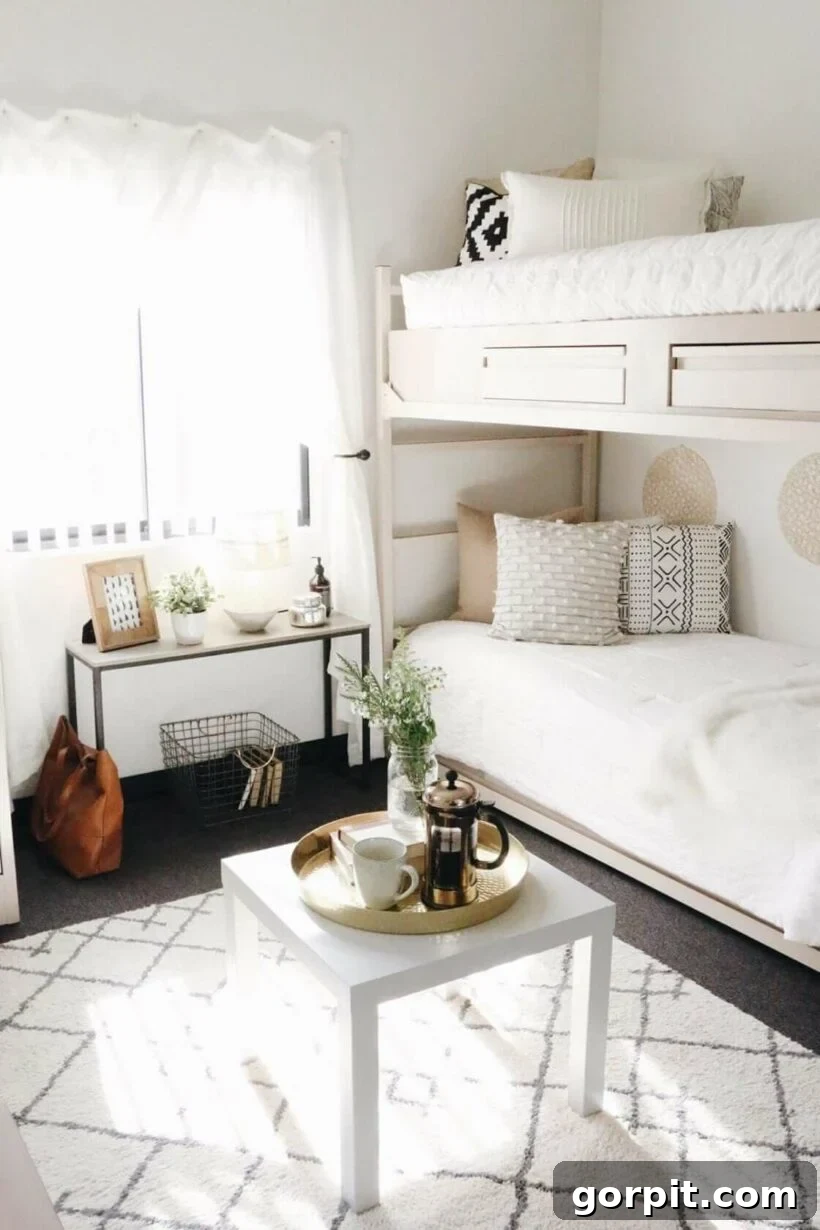 A black and white boho dorm room idea with a bunk bed with white and neutral bedding with a slim table under the window and a square coffee table.