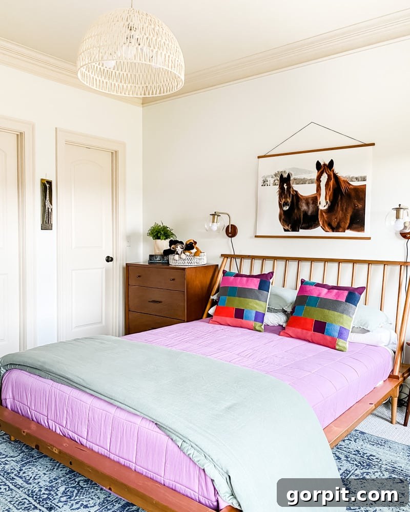 An 8' x 10' rug chosen for a queen-size bed in a modern girl's bedroom, showcasing layered rug placement over carpet.