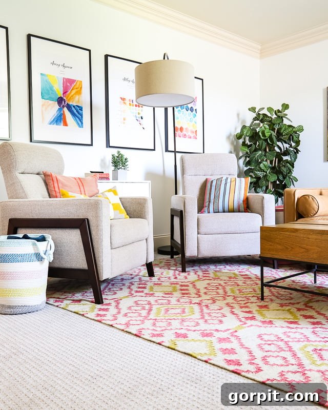 Two accent chairs sit in a colorful family room on pink graphic print area rug, featuring an Annie Selke design.
