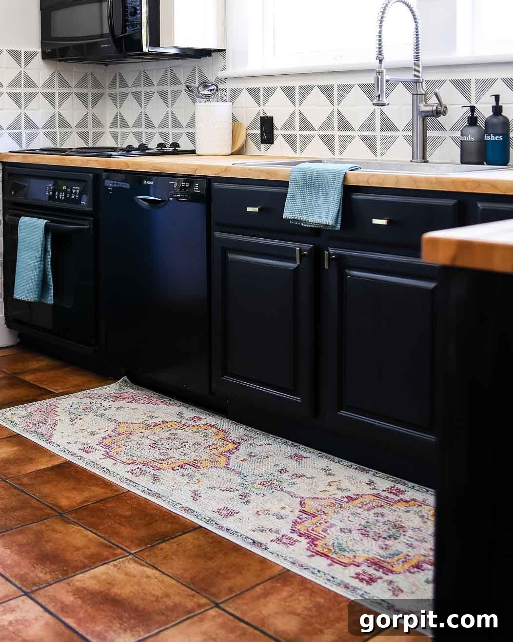 Elevate Your Kitchen Runner Style 3 A length of muted-colors medallion kitchen rug runner in a black and white kitchen.