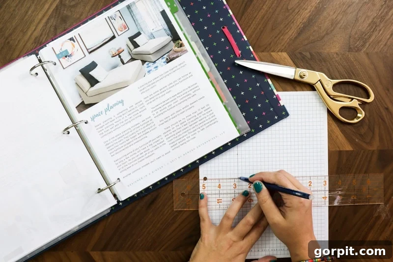 A person meticulously drawing out a space plan on graph paper, demonstrating the practical application of space planning principles.
