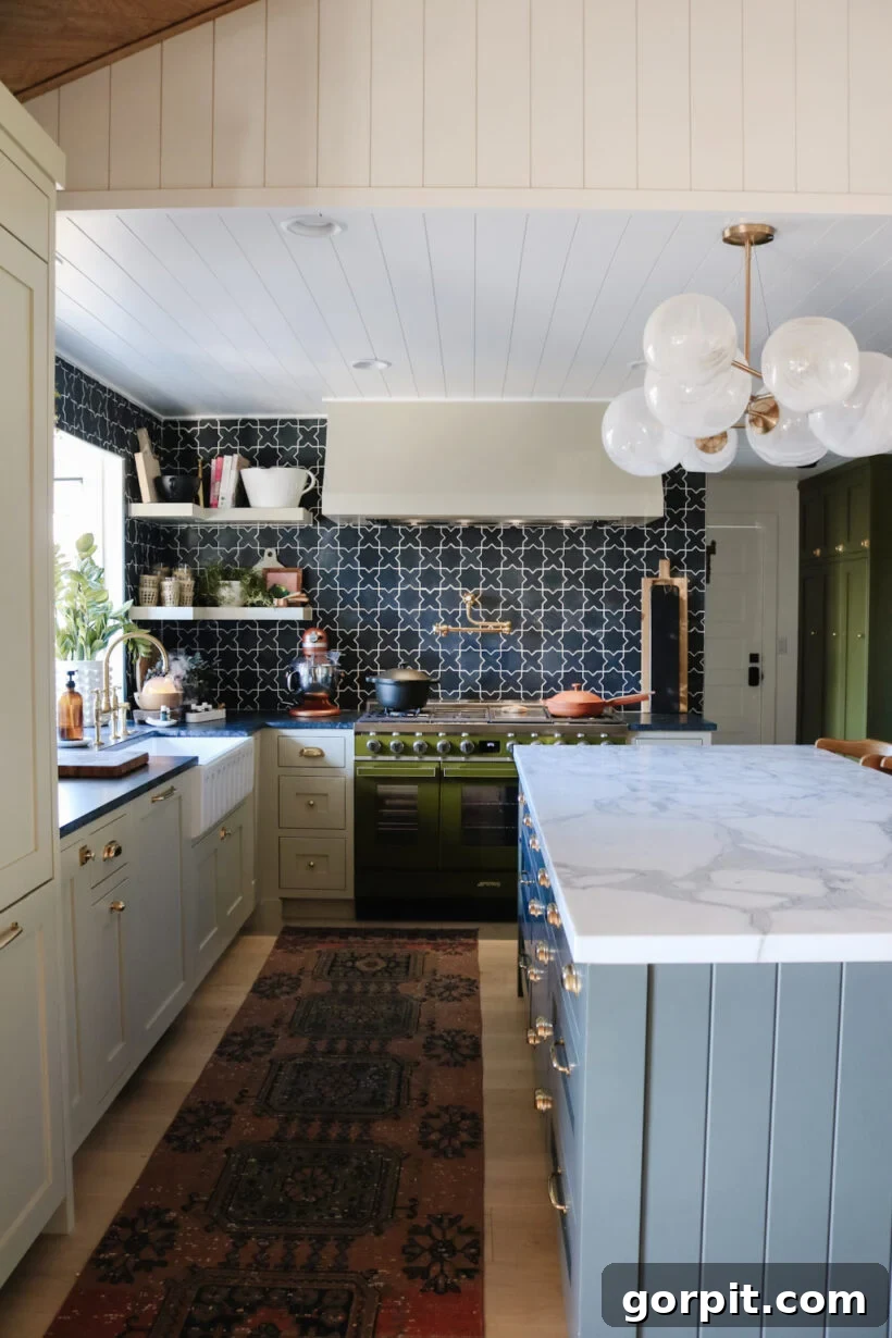 Elevate Your Interiors Innovative Accent Wall Designs 18 A geometric tile wall in a kitchen with a marble island and green stove, showcasing a bold and modern design choice that serves as an artistic accent.