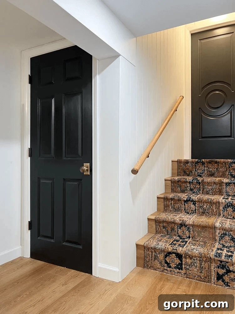 A warm wooden handrail features elegant brass accents, paired with an antique-style runner, creating a cozy and stylish staircase.