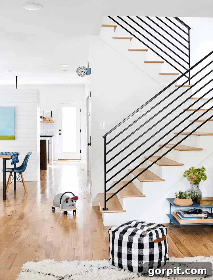 Sleek black horizontal metal stair railings update a modern farmhouse home, giving it a more open and contemporary feel.