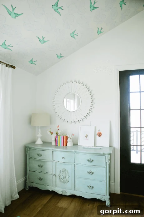 farmhouse girls' bedroom with bird wallpaper on ceiling, utilizing the 'fifth wall'