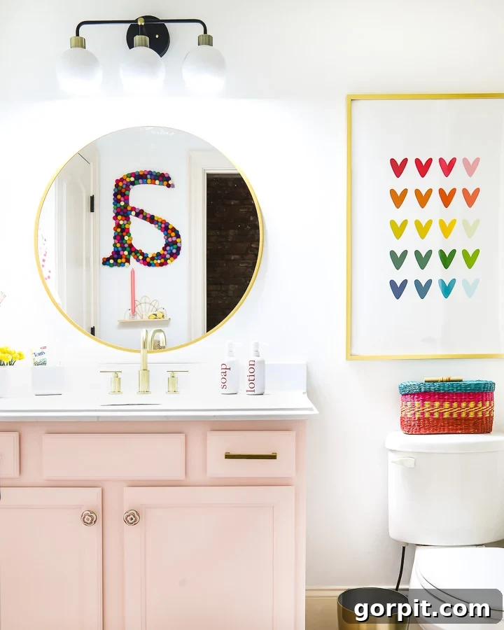 Colorful girl's bathroom reflecting a large wall letter in the mirror, highlighting playful decor.