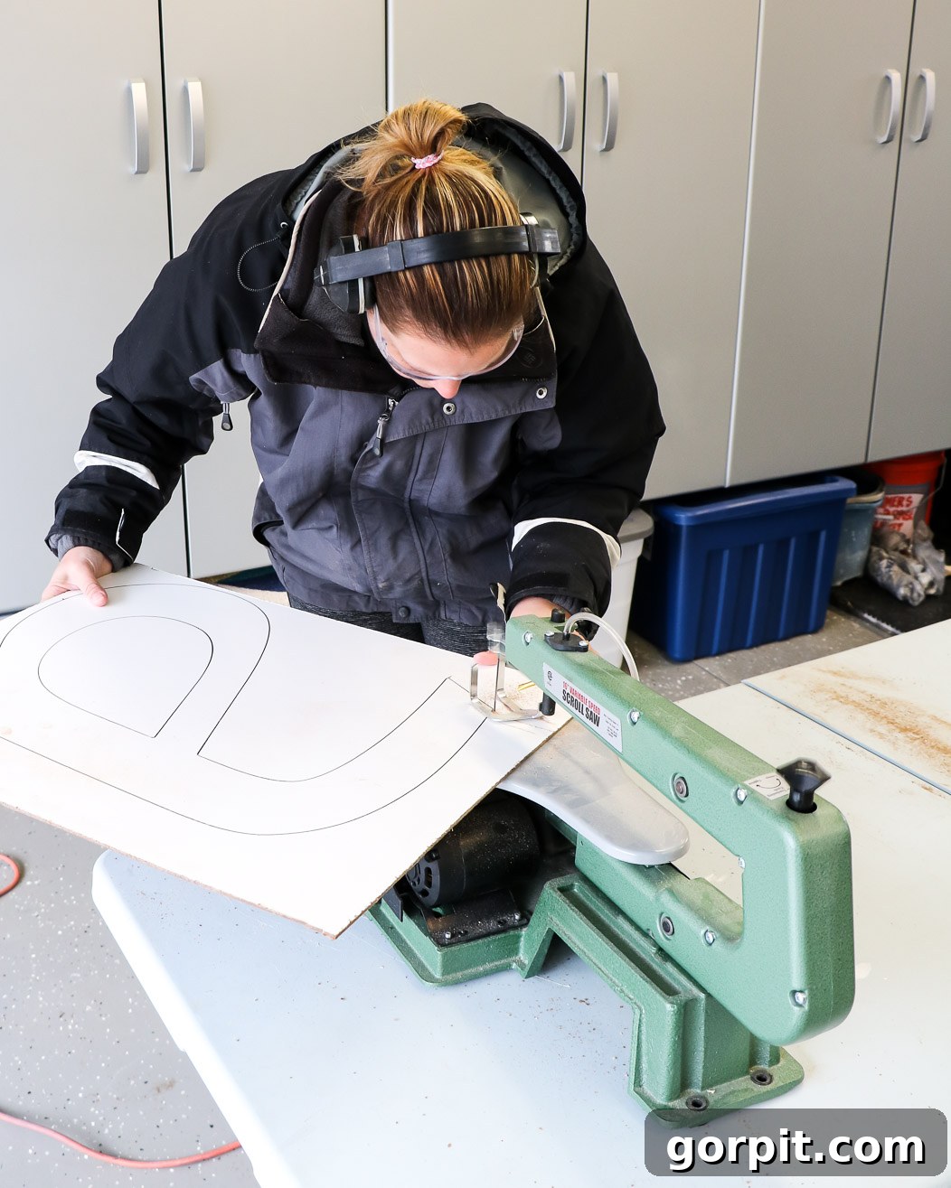 Elevate Your Decor with Handmade Giant Letters 4 Woman cutting out a large DIY wall letter with a scroll saw, demonstrating the crafting process