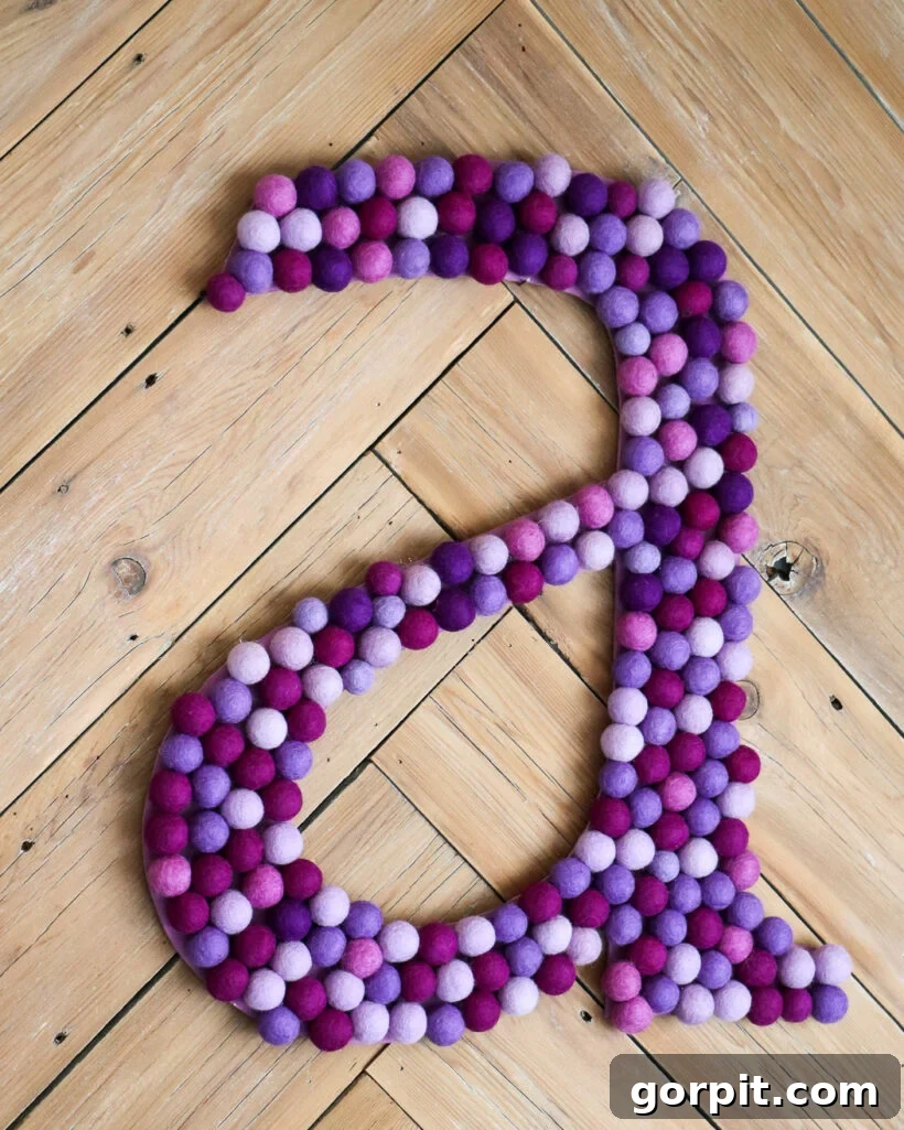 Elevate Your Decor with Handmade Giant Letters 8 A large, vibrant wall letter 'A' crafted with felt balls, adding a personalized touch to the room.
