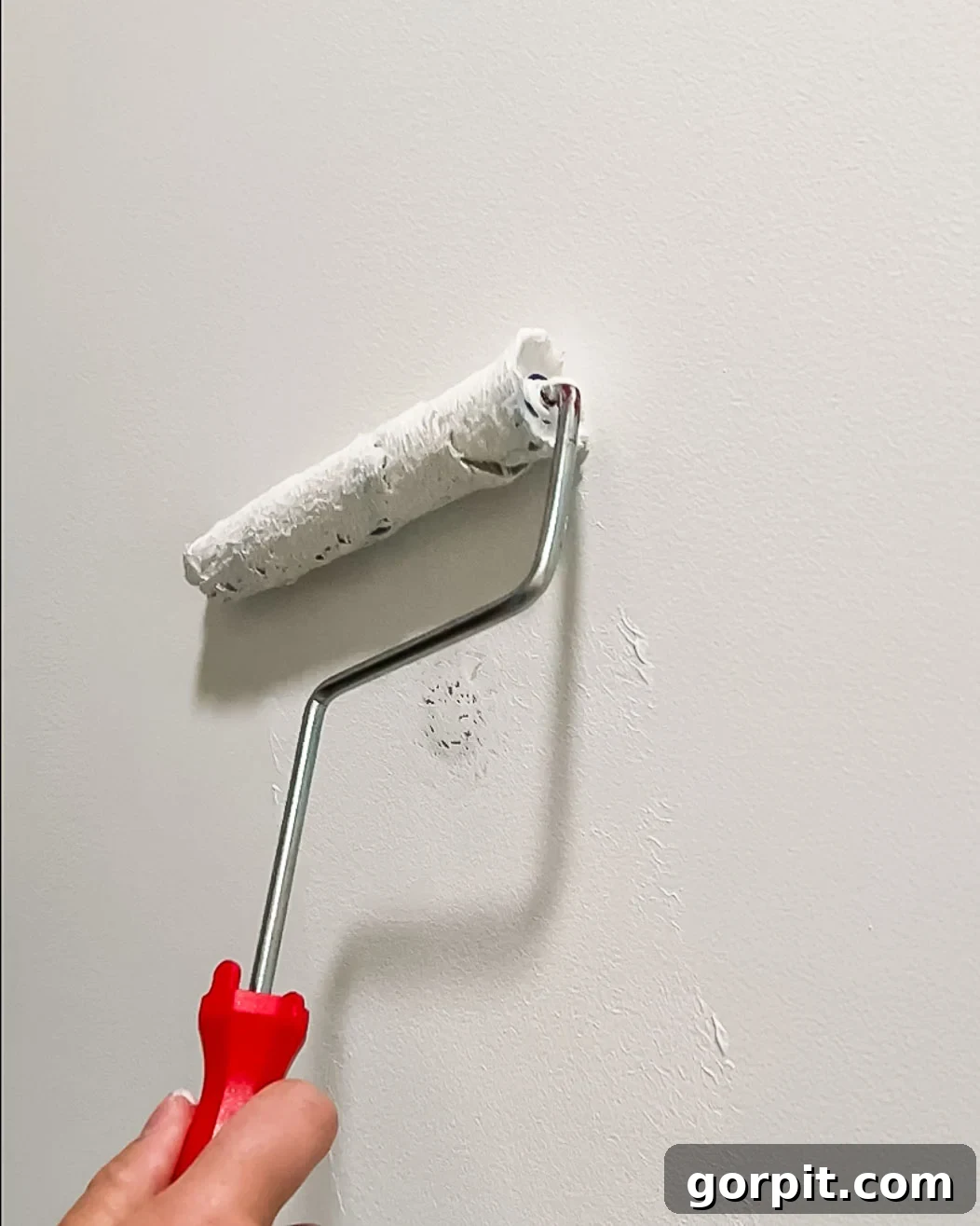 woman painting over DAP Eclipse repair patch with paint roller