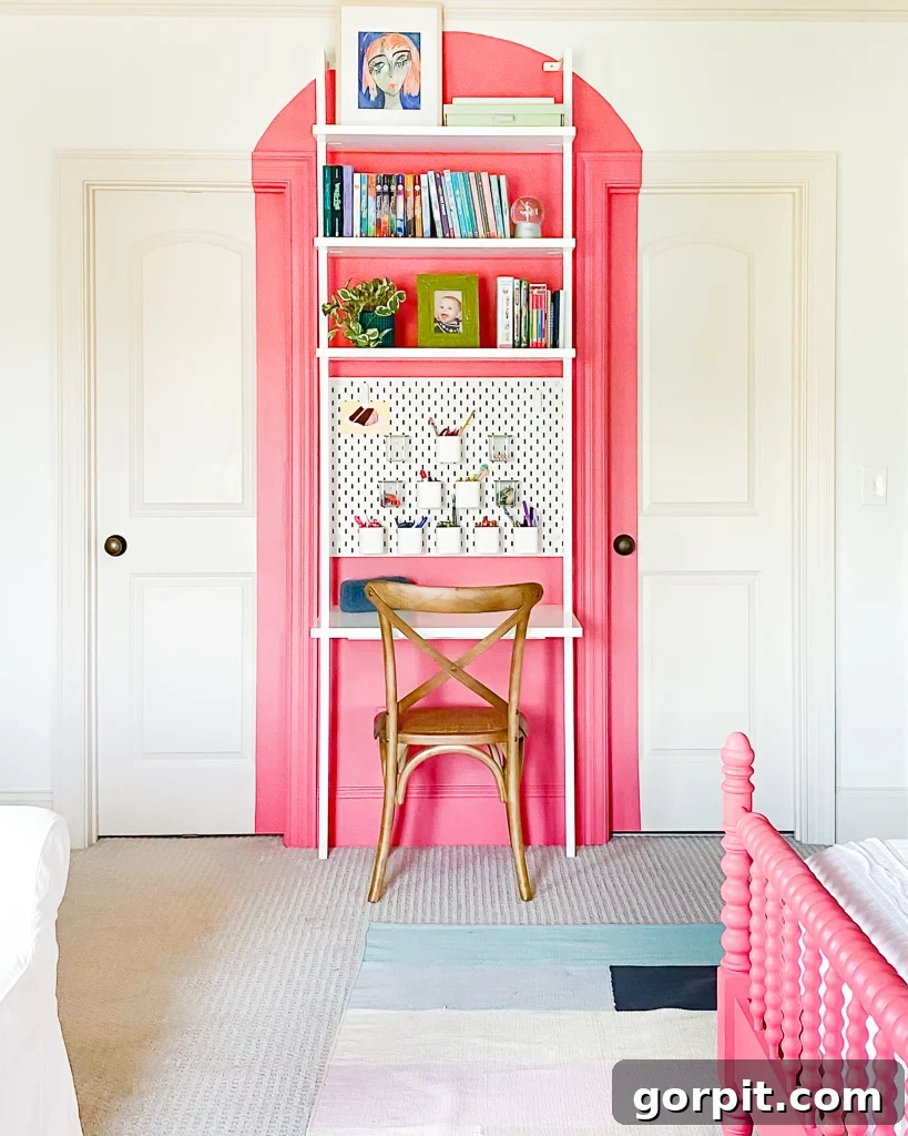 coral arch painted behind a wall-mounted desk with a wood chair