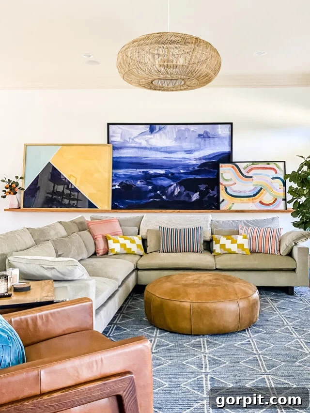 family room with beige couch and large wall art leaning on an art ledge