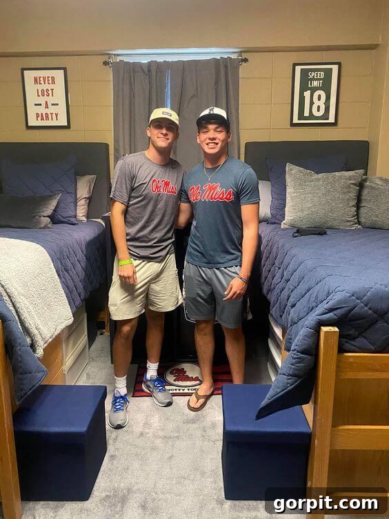 The Modern Guy's Dorm Room Playbook 4 Two roommates standing proudly in their dorm room, featuring coordinated blue bedding and organized living space.