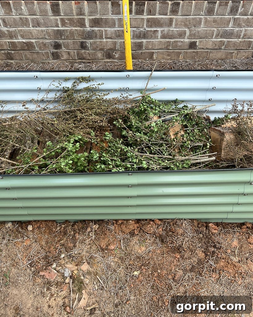 Illustrative image of the Hugelkultur method being used to fill a Vego garden bed, showing layers of organic material beneath the topsoil.