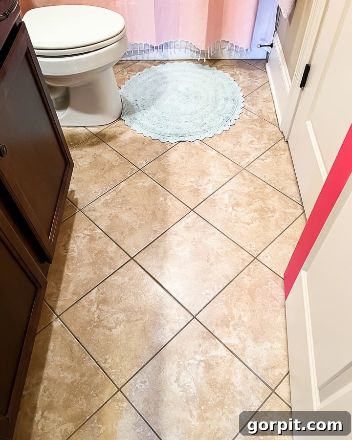 Affordable Bathroom Transformations: Smart DIY Renovation Ideas 18 Outdated brown bathroom floor tile before applying tile stickers.