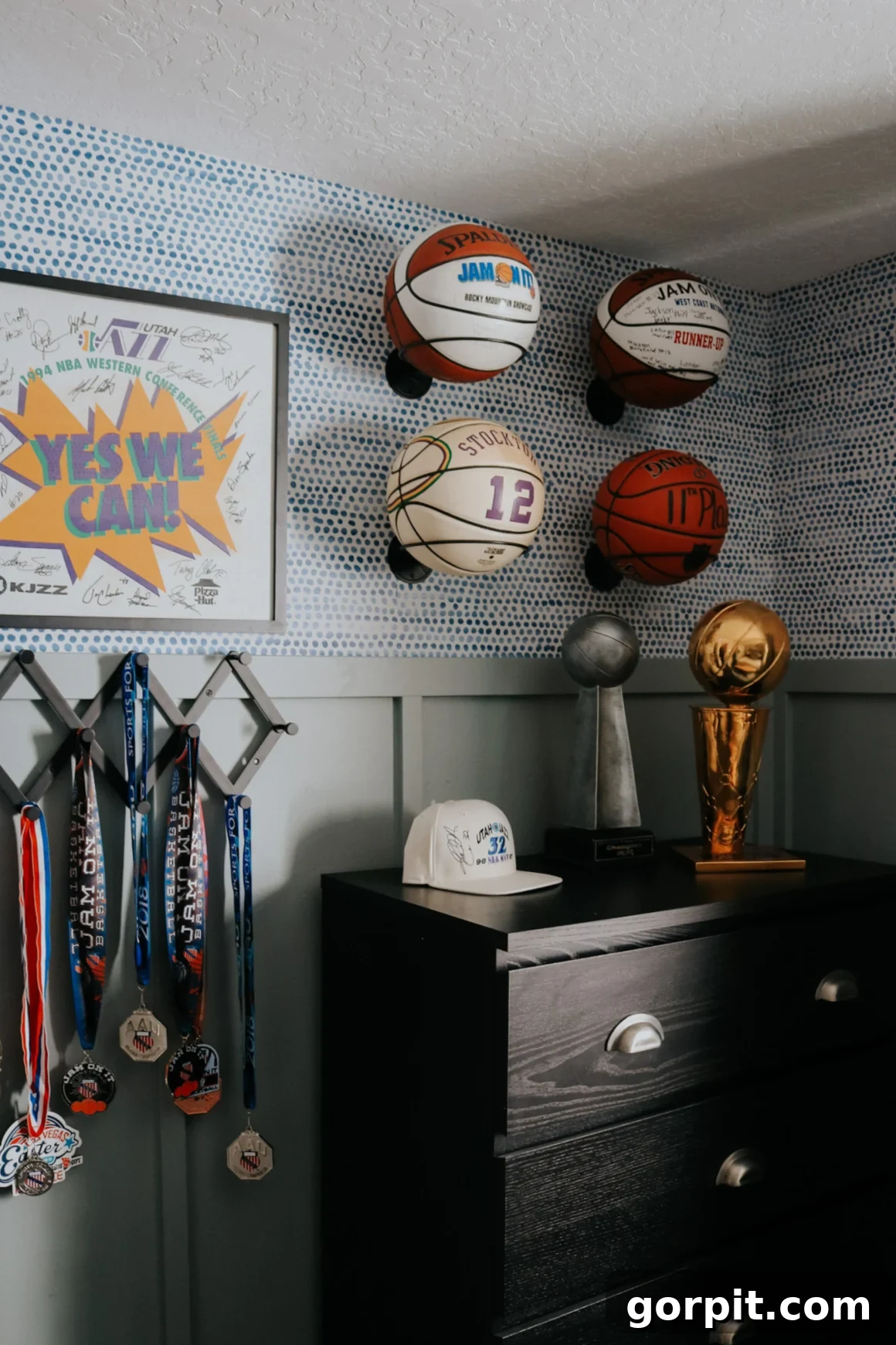25 Fresh Teen Room Makeover Ideas for Guys and Girls 23 Basketballs creatively arranged as wall art in a teen boy's bedroom, positioned above a dark dresser and adjacent to hanging awards. This unique decor highlights a passion for sports.