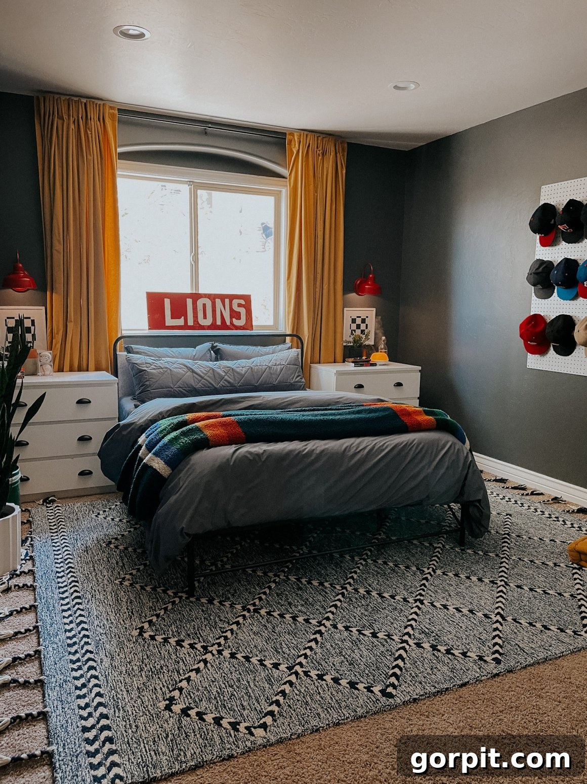 25 Fresh Teen Room Makeover Ideas for Guys and Girls 27 A cozy teen boy's bedroom beautifully balances light and dark colors, featuring crisp white dressers that cleverly serve as nightstands. A pegboard adorned with baseball hats acts as personalized wall art, adding a touch of sporty charm.