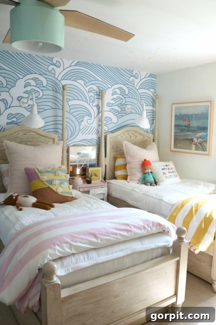 beds with colorful stuffed animals and striped blankets in front of wave wallpaper with colorful sconces