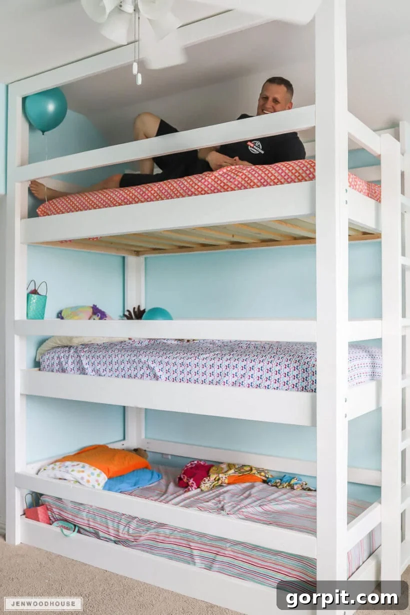 DIY triple bunk beds with man laying on the top one
