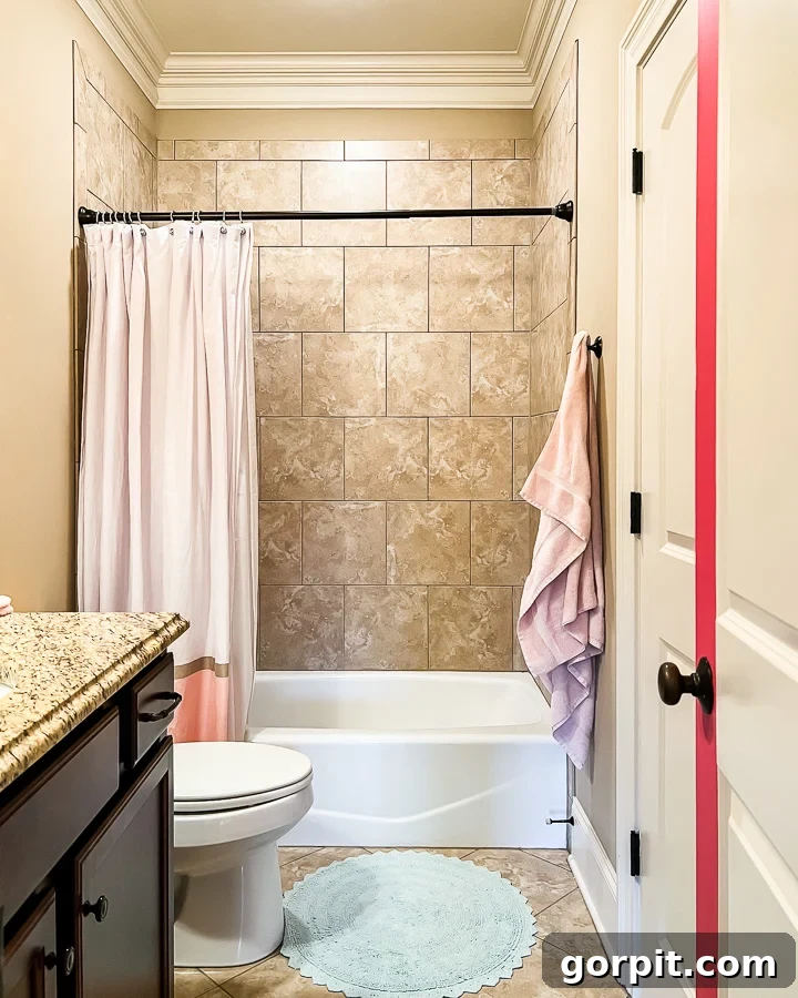 Outdated brown tile shower in girl's bathroom BEFORE the tile-over-tile project