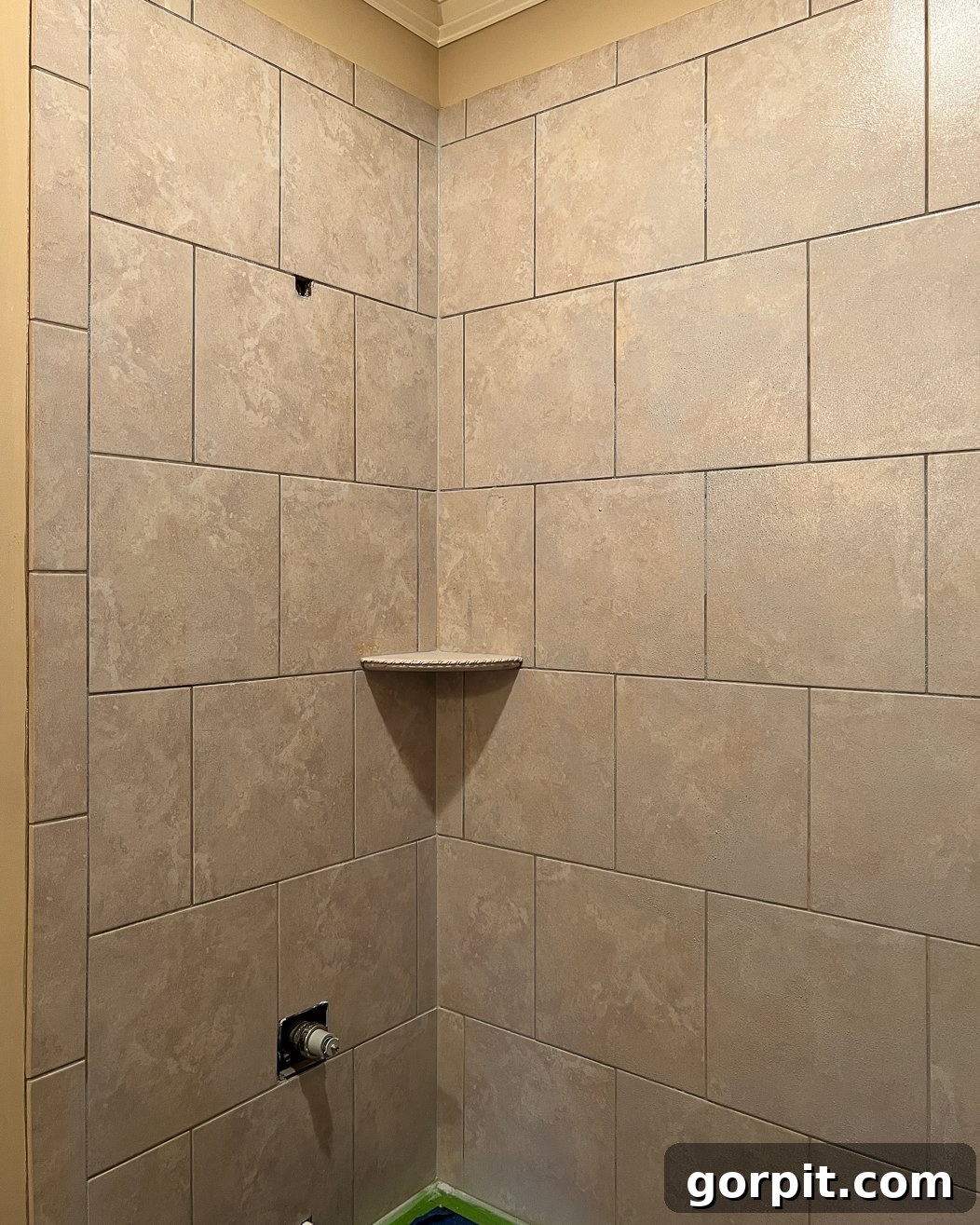Tile shower wall primed with Eco Prim Grip, showing a grayish hazy finish
