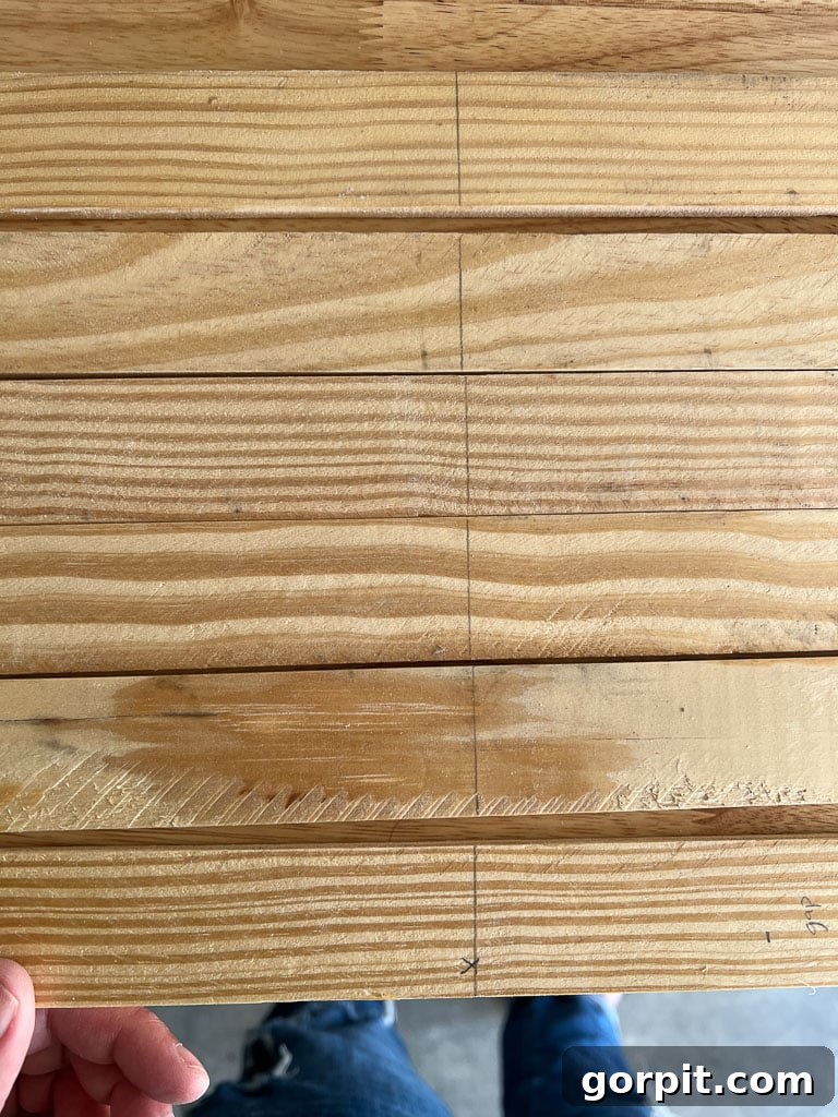 Pencil marks on lattice strips indicating precise magnet spacing and vertical placement for DIY magnetic poster hangers.
