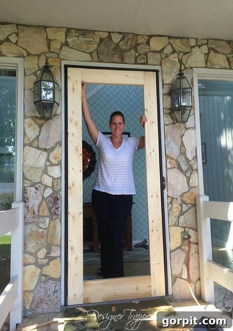 Dry fitting the assembled outer frame of the DIY screen door into the existing door frame.