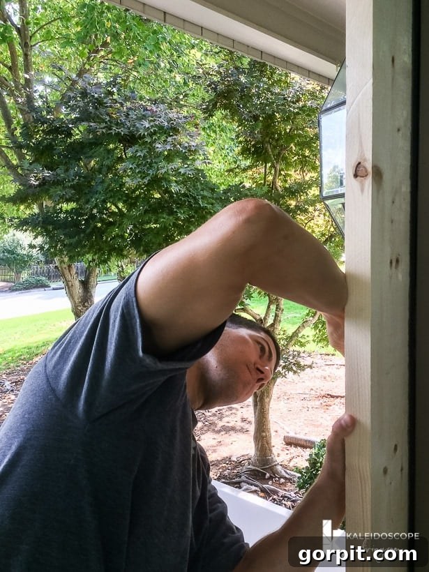 Marking the exact hinge placement on the DIY screen door frame for precise installation.