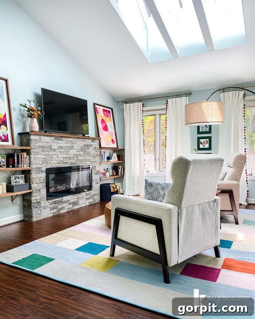 stylish recliners in sitting area of bedroom by Tasha Agruso of Kaleidoscope Living, featuring a modern electric fireplace