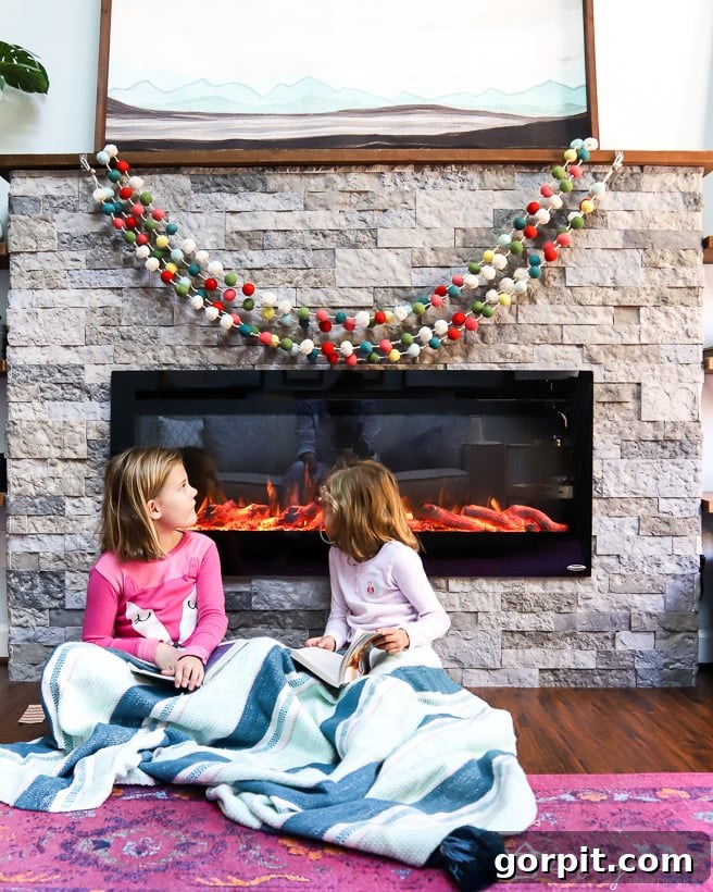 DIY electric fireplace with two girls sitting comfortably in front of it