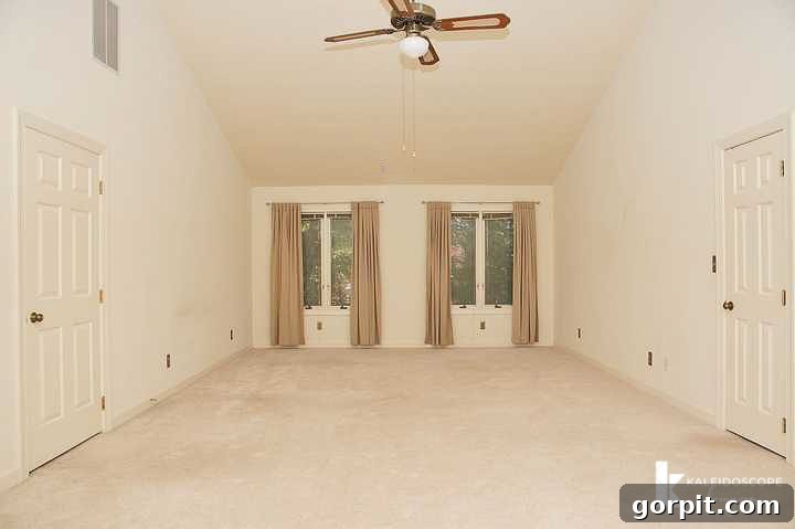 another view of the outdated, beige primary bedroom before renovation