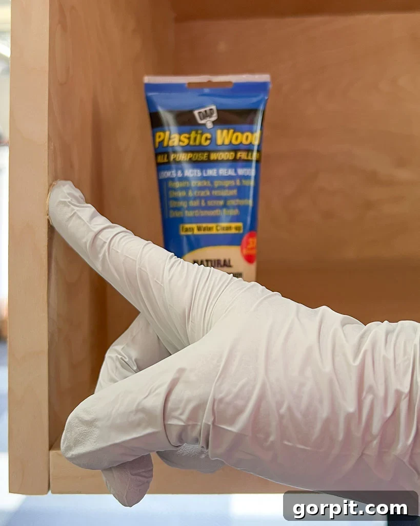 filling imperfections in DIY dog crate made of plywood with DAP Plastic Wood wood filler