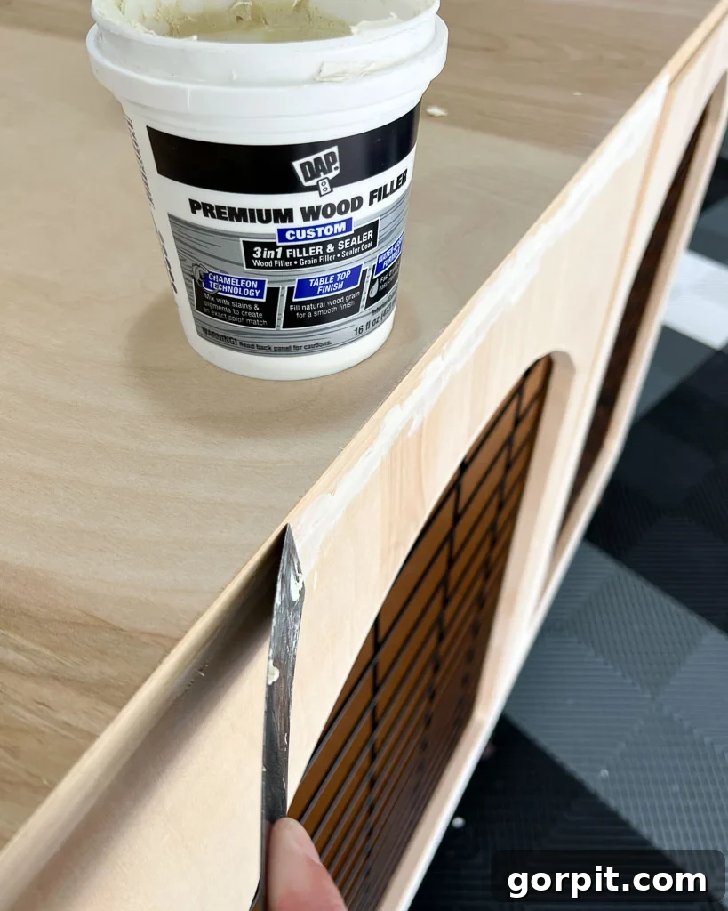 filling gaps along frame of wooden DIY dog crate with wood filler