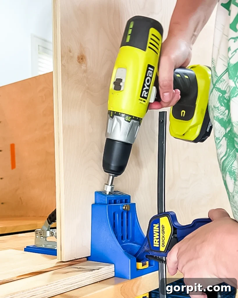 woman's hands drilling pocket holes in plywood using Kreg jig