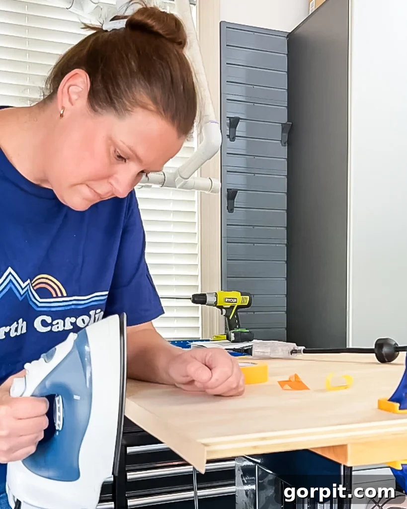 woman ironing edge banding onto edges of plywood