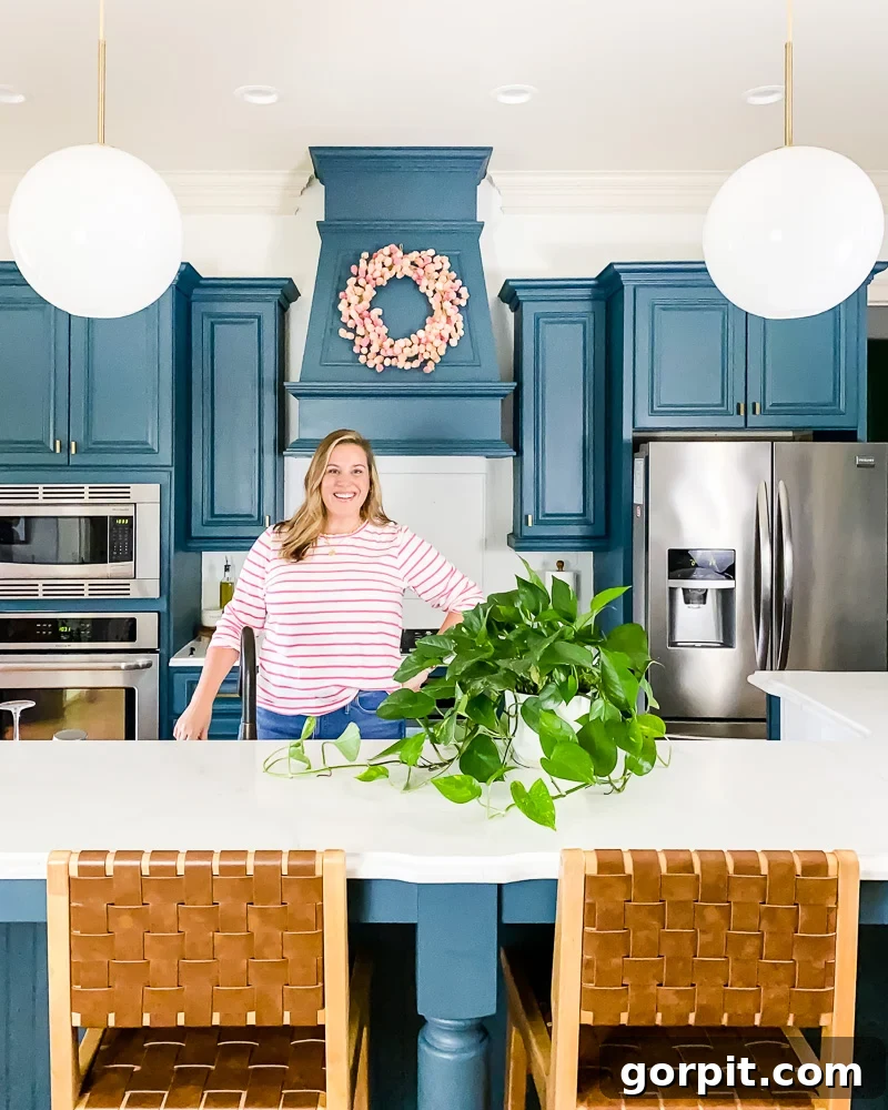 Painted Countertops The Long Haul Report 7 Woman standing in kitchen with DIY painted cabinets and countertops, looking elegant