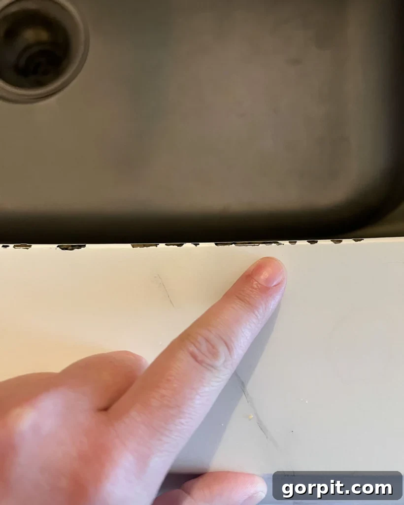 Painted Countertops The Long Haul Report 10 Photo showing chipped countertop paint along the edge of an under-mount kitchen sink after 3 years and 5 months