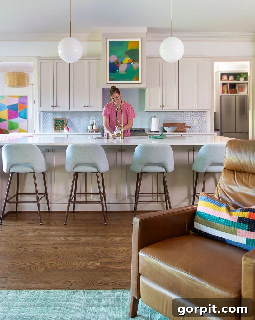 Our Kitchen Renovation Reveal A Perfect Blend of Neutral and Color 2 Tasha Agruso of Kaleidoscope Living happily washing dishes in her newly renovated kitchen, featuring cabinets painted in Accessible Beige by Sherwin Williams.