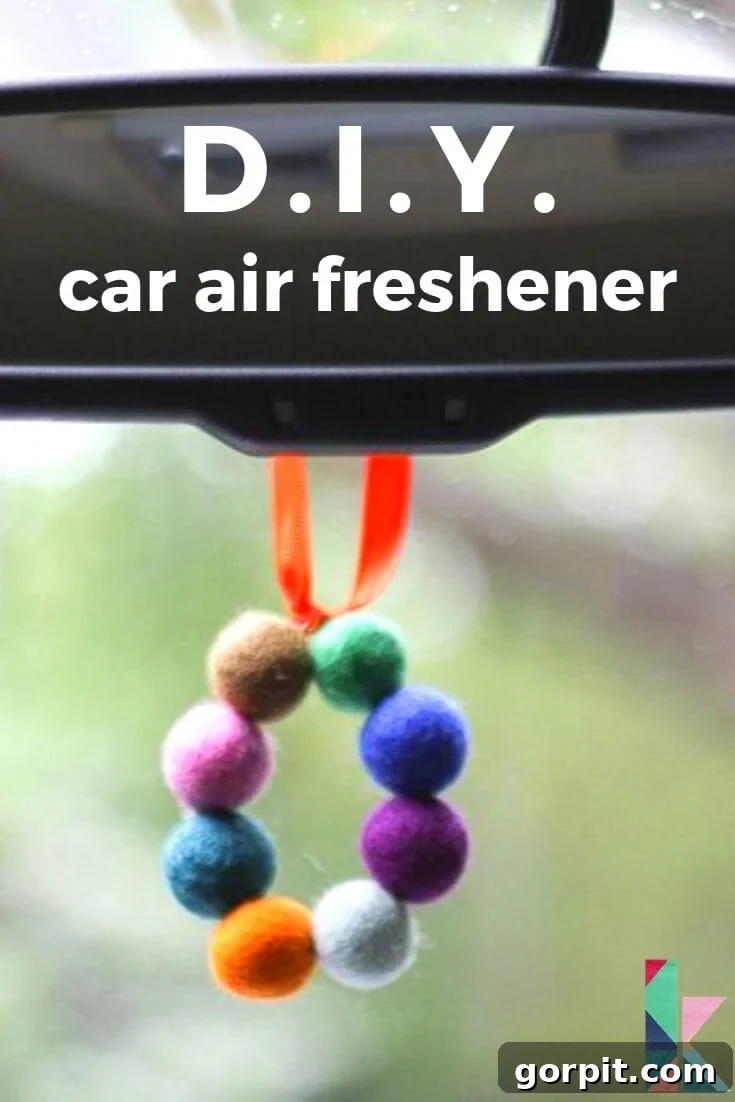 A close-up of a circle of fuzzy felt balls hanging from a rear-view window act as a DIY car air freshener. 
