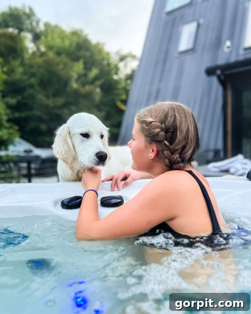 teenage girl in hot tub with English Cream Golden Retriever looking on