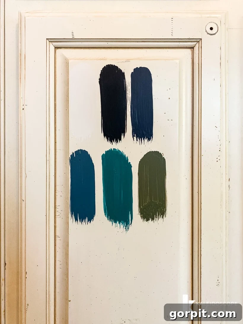 Kitchen Cabinet Painting My Three-Time DIYers Proven Process 12 photo of five different paint color test swatches from Fusion Mineral Paint painted on cream colored kitchen cabinet door
