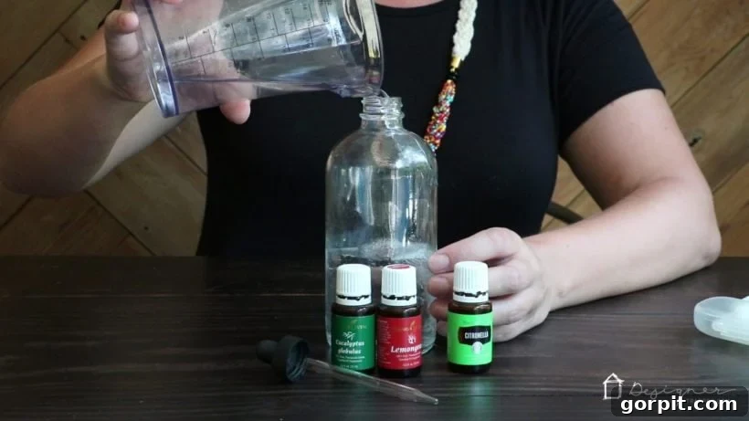 Homemade Chemical-Free Bug Defense 4 Adding witch hazel to the glass bottle for homemade essential oil bug spray, acting as an emulsifier for the natural repellent recipe.