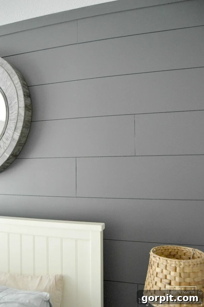 Complete view of a beautifully styled guest room featuring a DIY wood plank accent wall