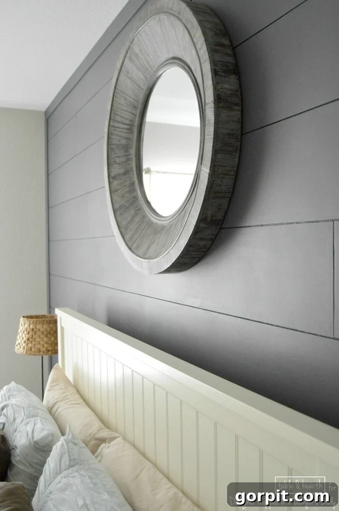 Stylish guest bedroom featuring a DIY wood plank wall, showcasing decorative elements
