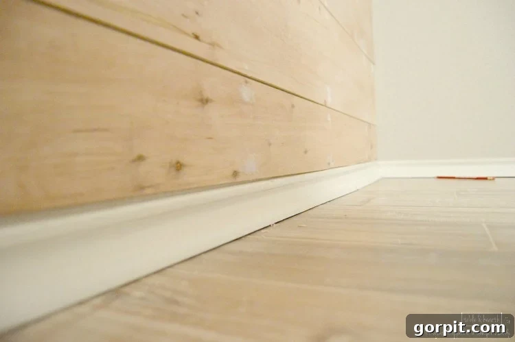 Close-up of a newly installed DIY wood plank wall showing even gaps