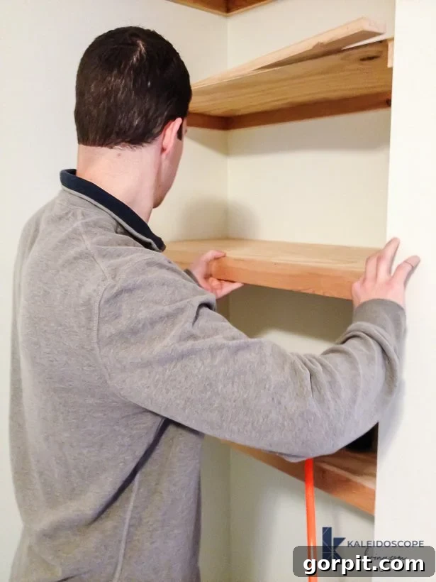man installing DIY floating shelves in corner of bedroom